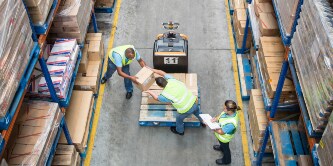 工作人員將紙箱從棧板搬上貨架的俯視圖
