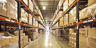  Image of the view down a long row of stacked warehouse shelves
