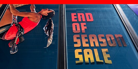 大型櫥窗玻璃商用彩繪膠膜展示攀岩者與促銷廣告。
