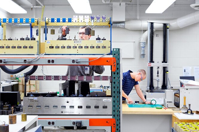 Two men in a 3M lab testing numerous electronics bonding capabilities.
