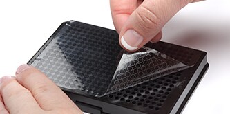 Close-up pf handsnplacing a 3M™ Bioassay Compatible Adhesive onto a black surface
