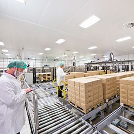 Image of masked workers in a clean white room keeping track of stacks of packages