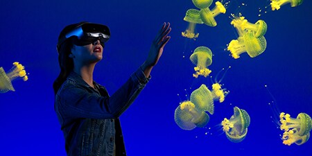 女士佩戴AR/VR頭盔探索水下體驗。
