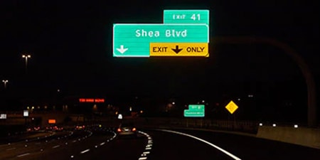 高速公路標識在夜間道路上展現出高度反光性。
