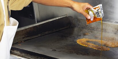 3M 百利煎板清潔液倒在加熱中的煎板表面
