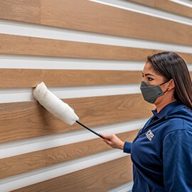 員工正在為木質牆面裝飾除塵。