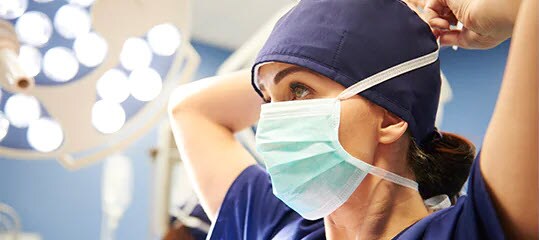 clinicain putitng on surgical mask
