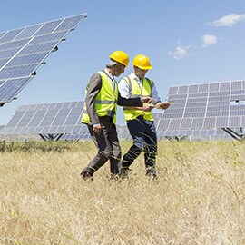 兩名男子走在旁邊的太陽能電池板