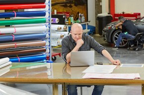 designer sitting at a computer designing a fleet graphic wrap