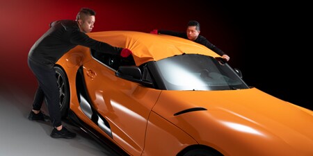 Installers applying vinyl 3M wrap film to car
