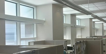 一排辦公室隔間正對著貼有 3M™ 日照導光膜的窗戶。
