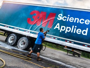 man washing the side of a truck wrapped with 3m graphic film
