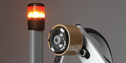 Image of a bright red light near a nearly-empty roll of tape
