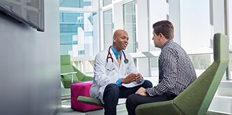 Doctor talking ot patient in bright lobby
