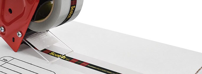 Image of a hand-held tape gun sealing a box with a Scotch® box sealing tape