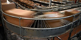 模糊的紙箱在輸送帶系統彎道處高速移動的圖片
