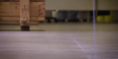 清潔後準備貼附地面標示膠帶的地面畫面，背景中可見一台推車。
