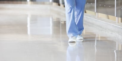 doctor walking through the hallway on a sparkling clean hospital floor