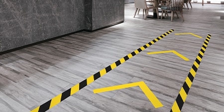 close-up view of 3M floor safety marking tapes applied in an arrow pattern.
