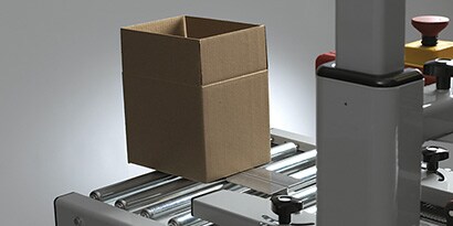 Image of an unsealed box held upright and open by the box hold-down attachment
