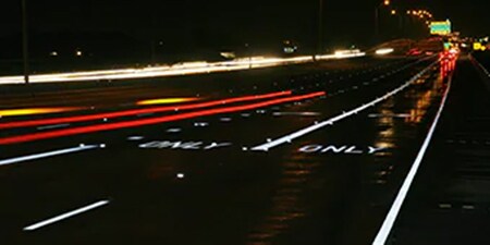 A highway at night with bright, reflective pavement markings.

