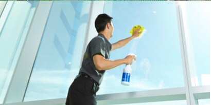 man cleaning interior of glass windows with a ready to use surface cleaner and cloth.
