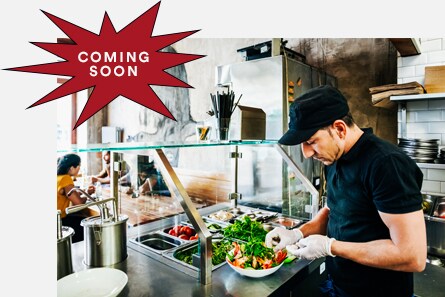 一名餐廳員工戴著食品服務手套正在準備沙拉。