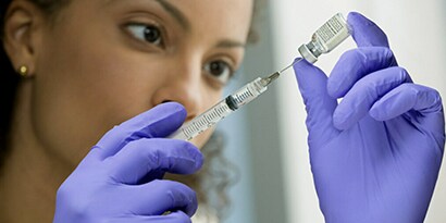 Woman using a syringe and a vial
