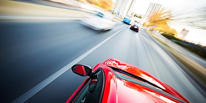 red car speeding down a freeway
