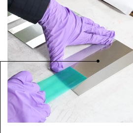 圖片顯示戴著手套的雙手移除 3M™ 聚酯膠帶 8992，留下清晰遮蔽線條且無殘膠
