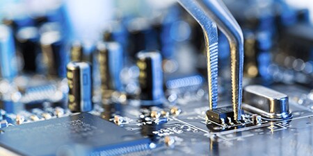 image of pliers being used on a circuit board capacitor
