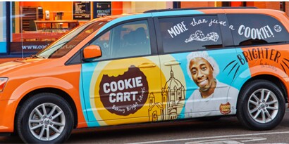 Minivan with colorful fleet graphics reading “Cookie Cart.”
