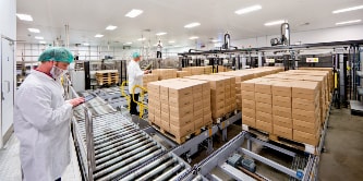 戴口罩的工作人員在乾淨的白色房間裡記錄一堆包裹的圖片
