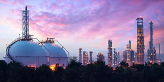 日落時分，工業煉油廠的照片，天空呈現出絢麗的紫色和粉紅色。
