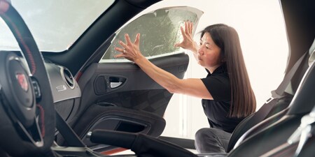 Installer applying a 3M Automotive Window Film to a car window
