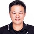 一張人物穿著黑色有領襯衫、背景為純白色的照片。