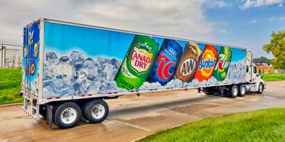 Semi-truck with images of soda cans on its fleet graphic wrap.