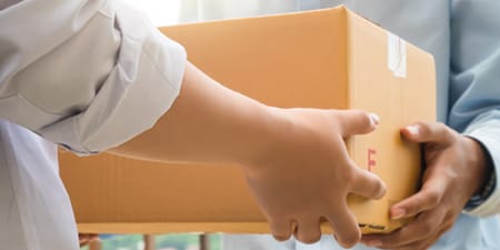 一人將紙箱遞給另一人。
